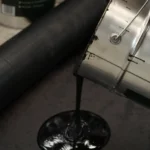 Een pot met koudlijm roofing van het merk Schütz wordt geleegd op een platform als voorbereiding om roofing te verlijmen.